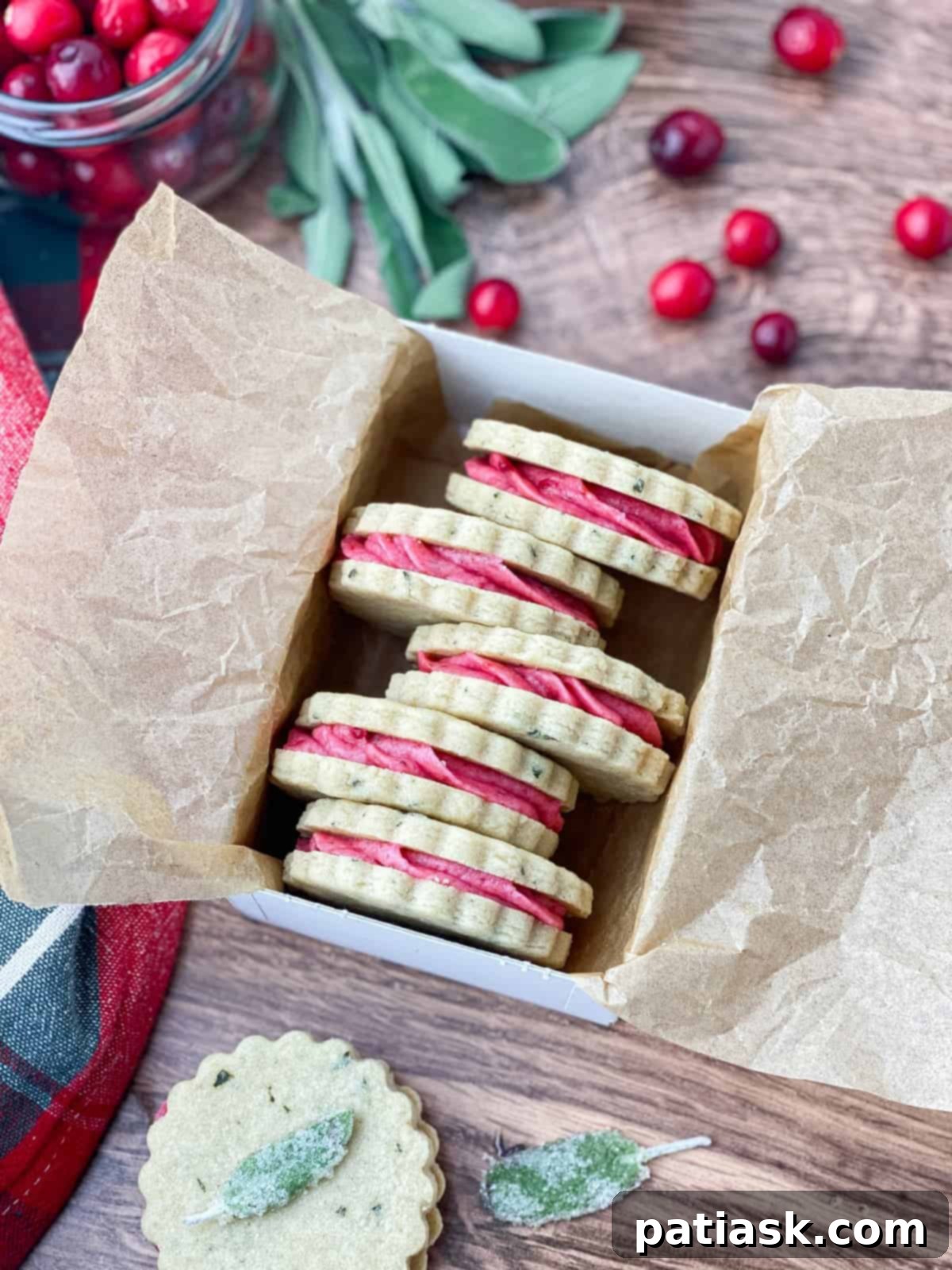 Delicate sage cookies topped with vibrant cranberry buttercream, showcasing their unique and elegant appearance.