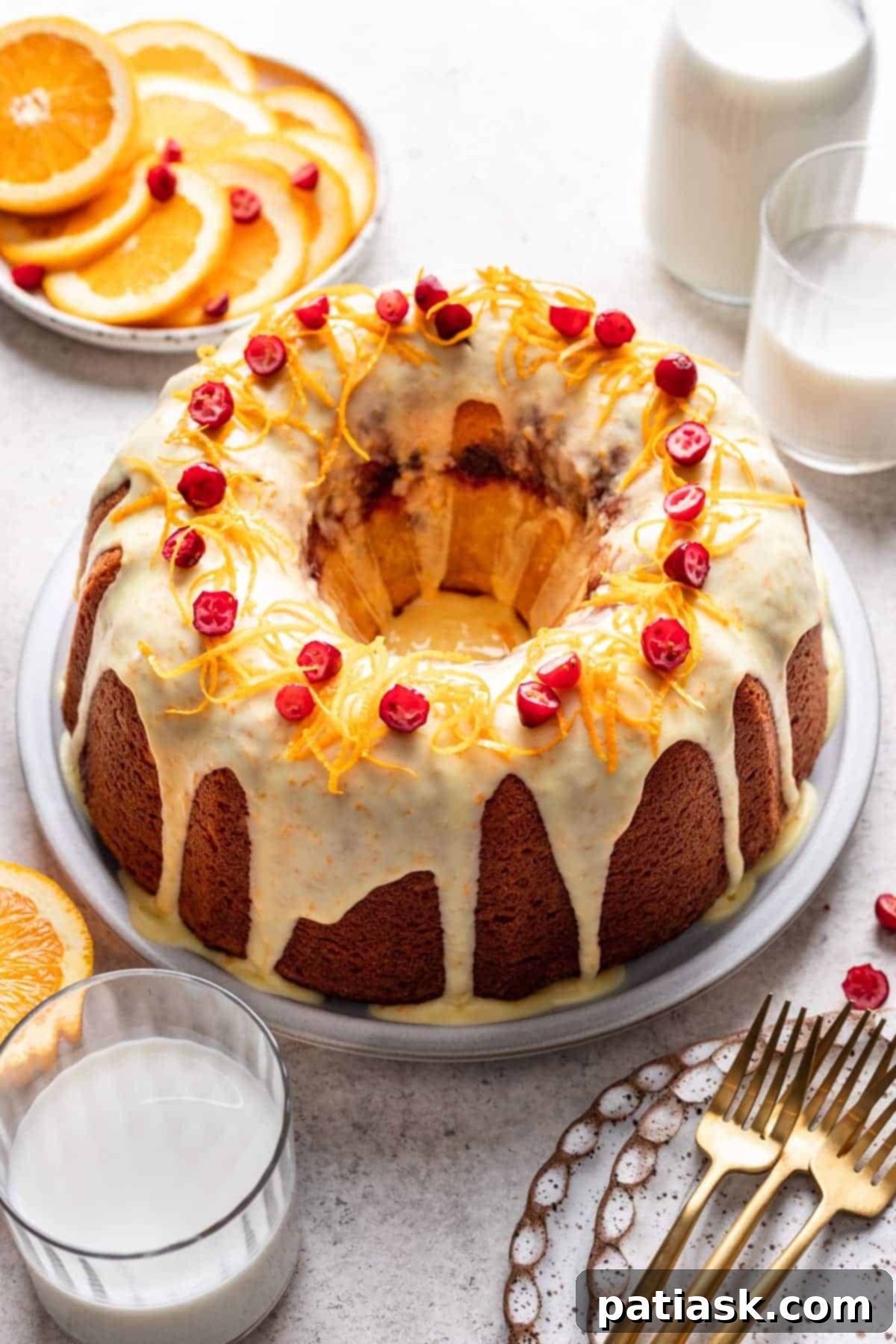 A beautifully sliced cranberry orange pound cake, topped with an orange glaze and fresh cranberries.