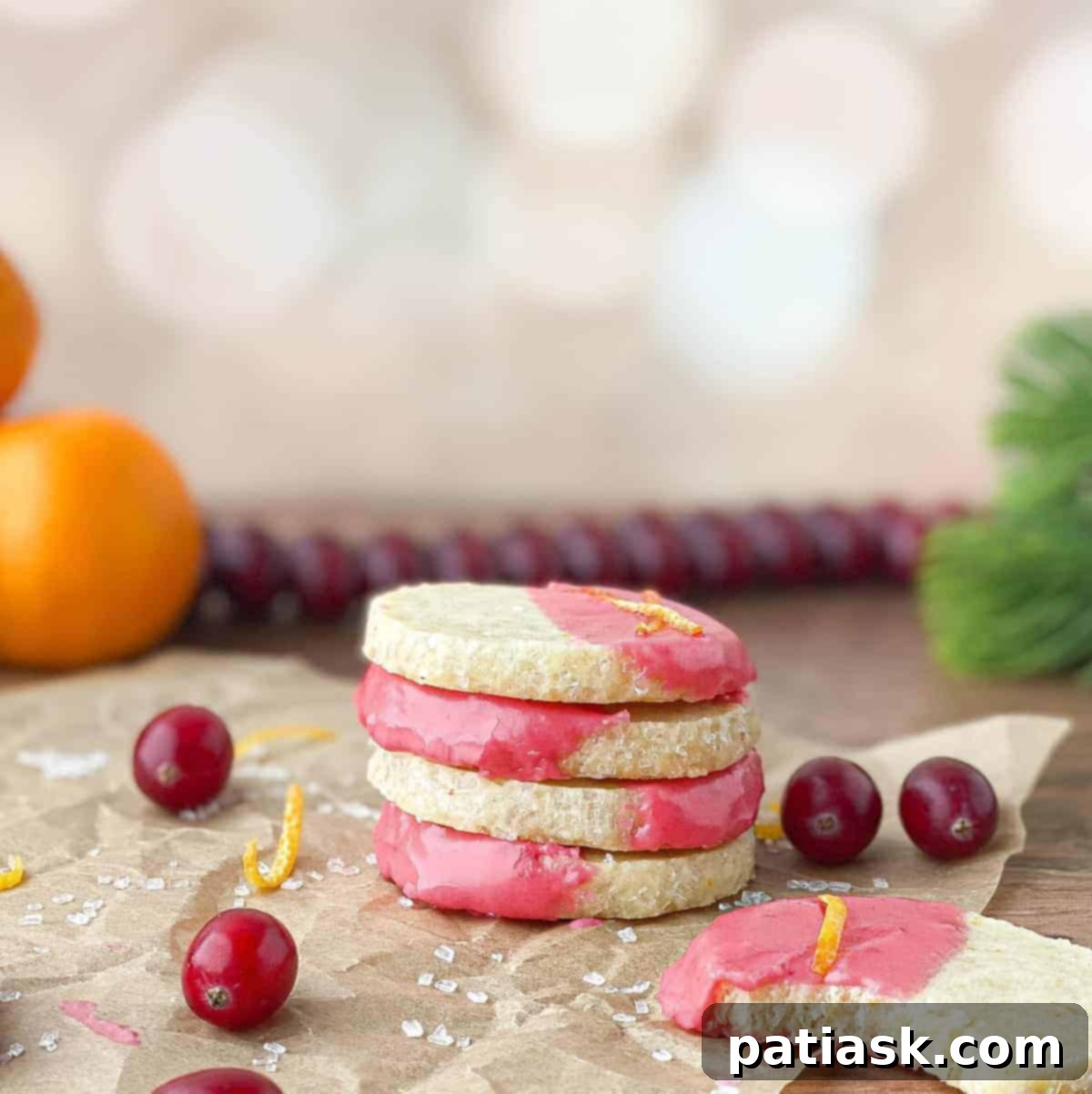 A stack of buttery orange shortbread cookies, artfully drizzled with a rich cranberry glaze.
