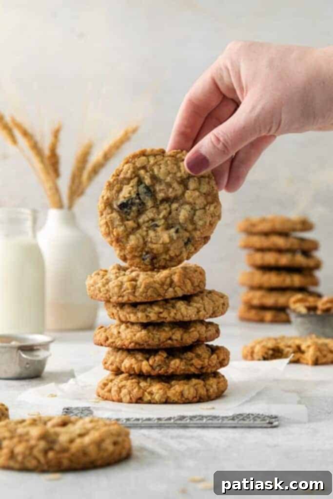 A stack of golden brown oatmeal cranberry walnut cookies on a cooling rack, showing their hearty texture.