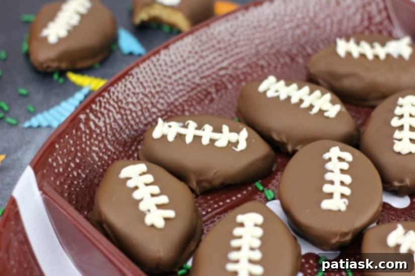 Touchdown Chocolate Peanut Butter Delights 6 A perfectly formed Homemade Chocolate Peanut Butter Cup Football, expertly decorated with white laces, resting on a white surface.