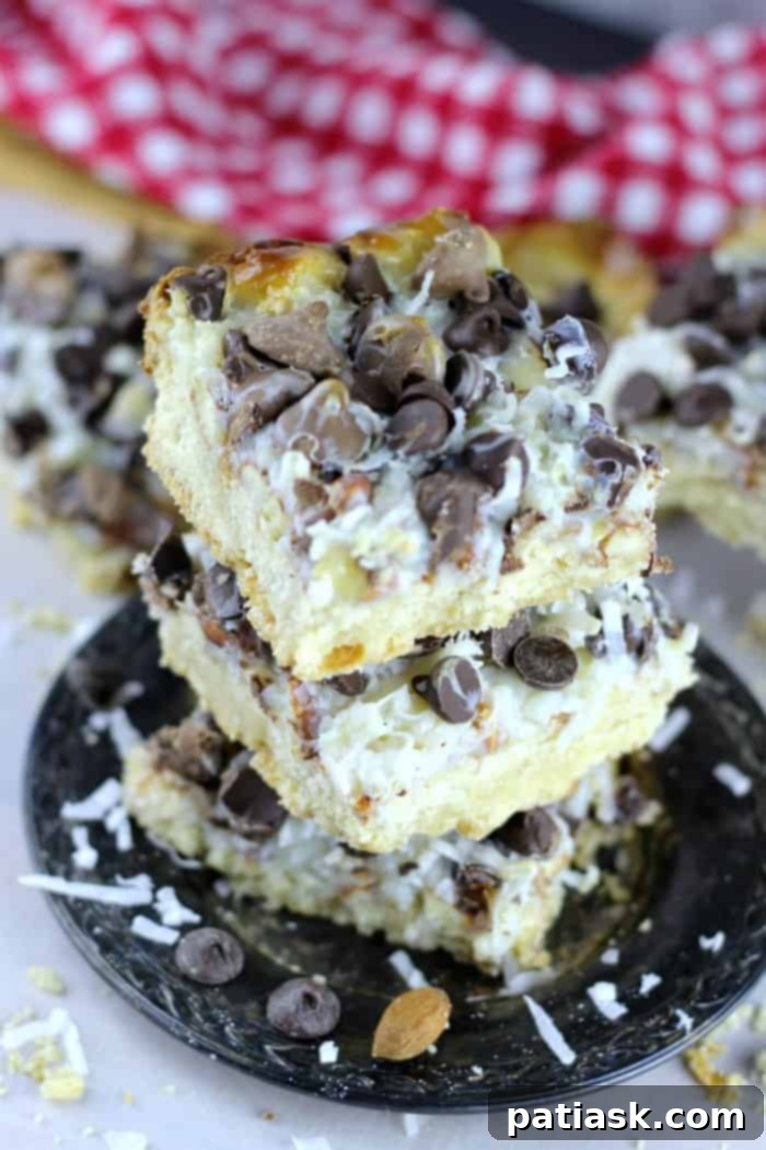 Ultimate Almond Joy magic bars with a buttery shortbread crust, coconut, almonds, and chocolate chips, a winning game day treat.