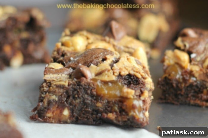 Ultimate fudgy Snickers brownies, loaded with Snickers candy bar bits for a pure indulgence, perfect for game day.