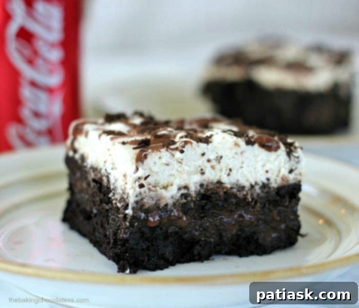 Whipped Chocolate Coca Cola poke cake, a moist chocolate cake infused with coke and topped with fluffy whipped cream, great for parties.