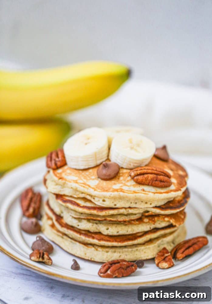 A bowl of fluffy banana chocolate chip pancake batter with a whisk, showing the perfect consistency before cooking.