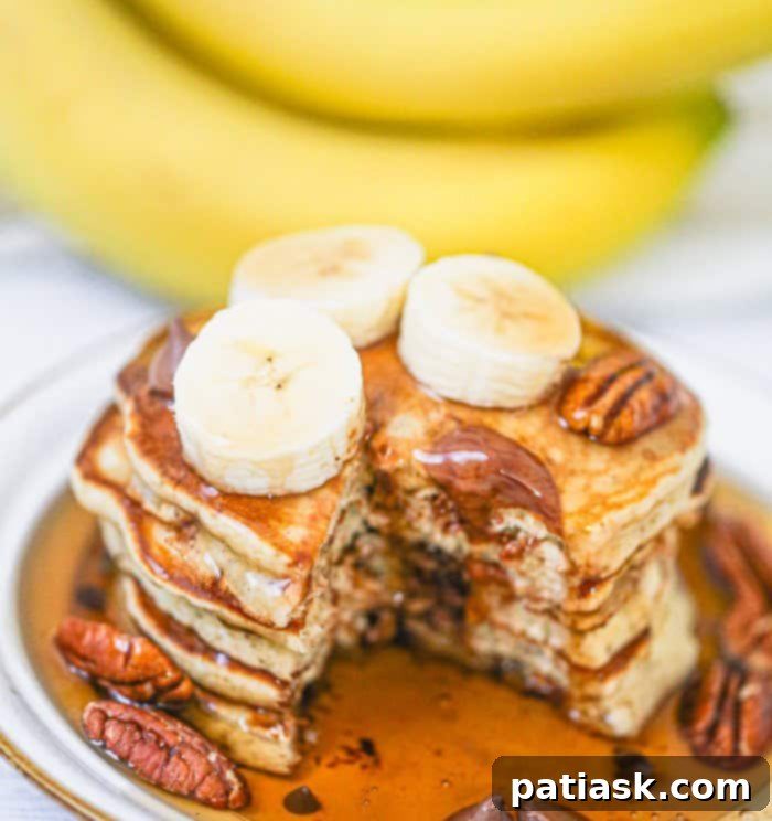 A close-up of a stack of golden-brown breakfast hotcakes, ready to be drizzled with syrup and enjoyed.