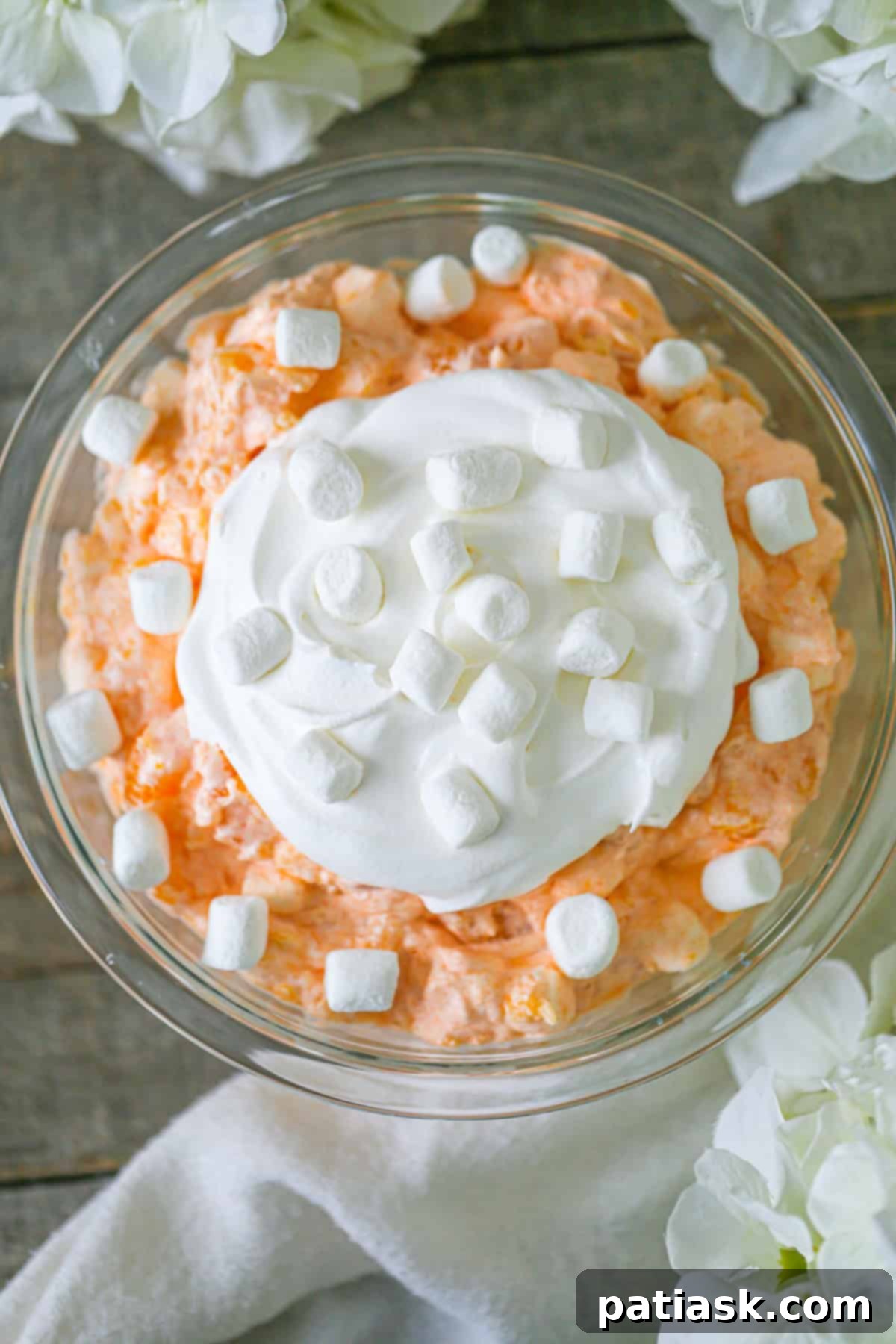 This easy Orange Fluff Salad recipe combines mandarin oranges, marshmallows, cottage cheese & jello. Quick to make & delightfully fluffy!