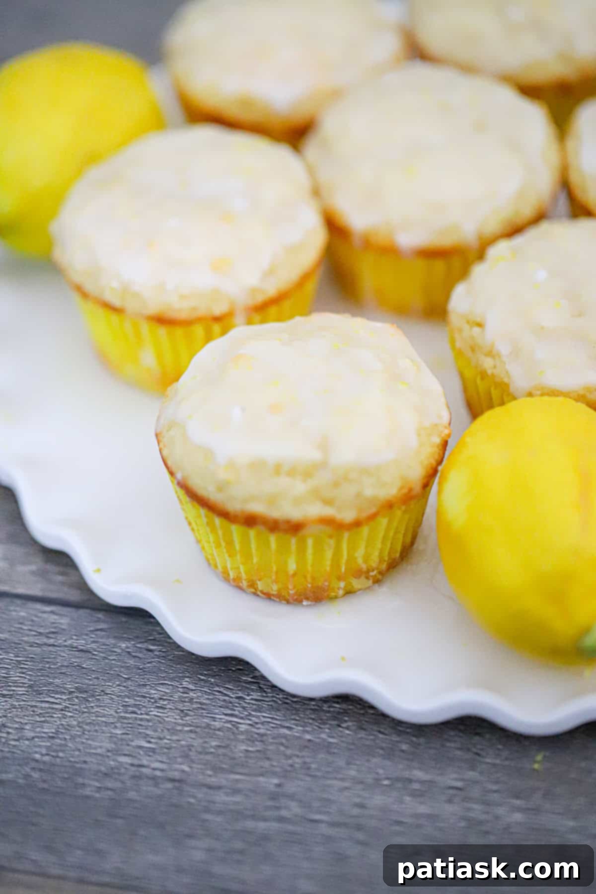 Tangy Lemon Yogurt Muffins 6 Stacked lemon yogurt muffins with a light drizzle of glaze