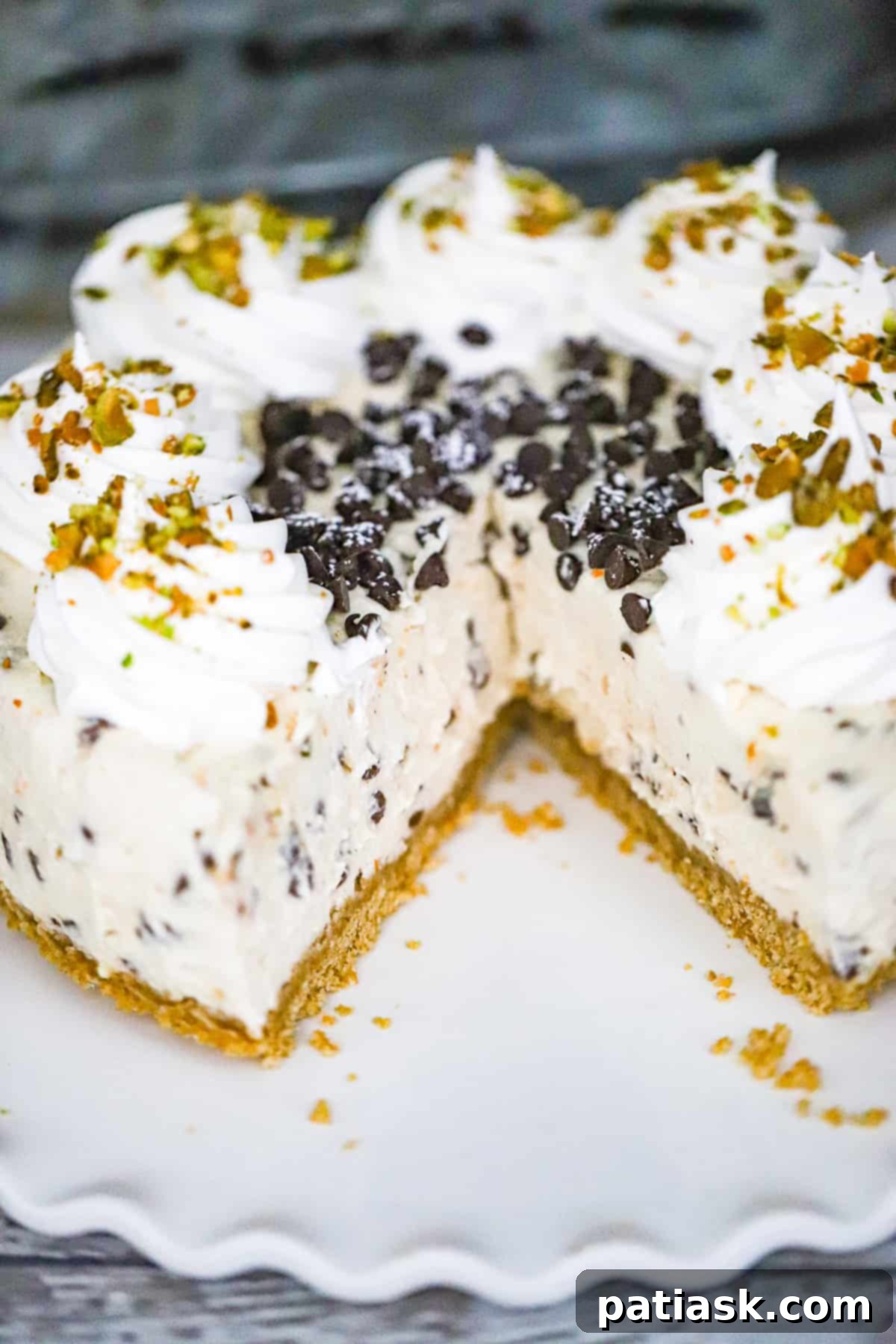 No-Bake Cannoli Cheesecake topped with a generous amount of chocolate chips and pistachios.