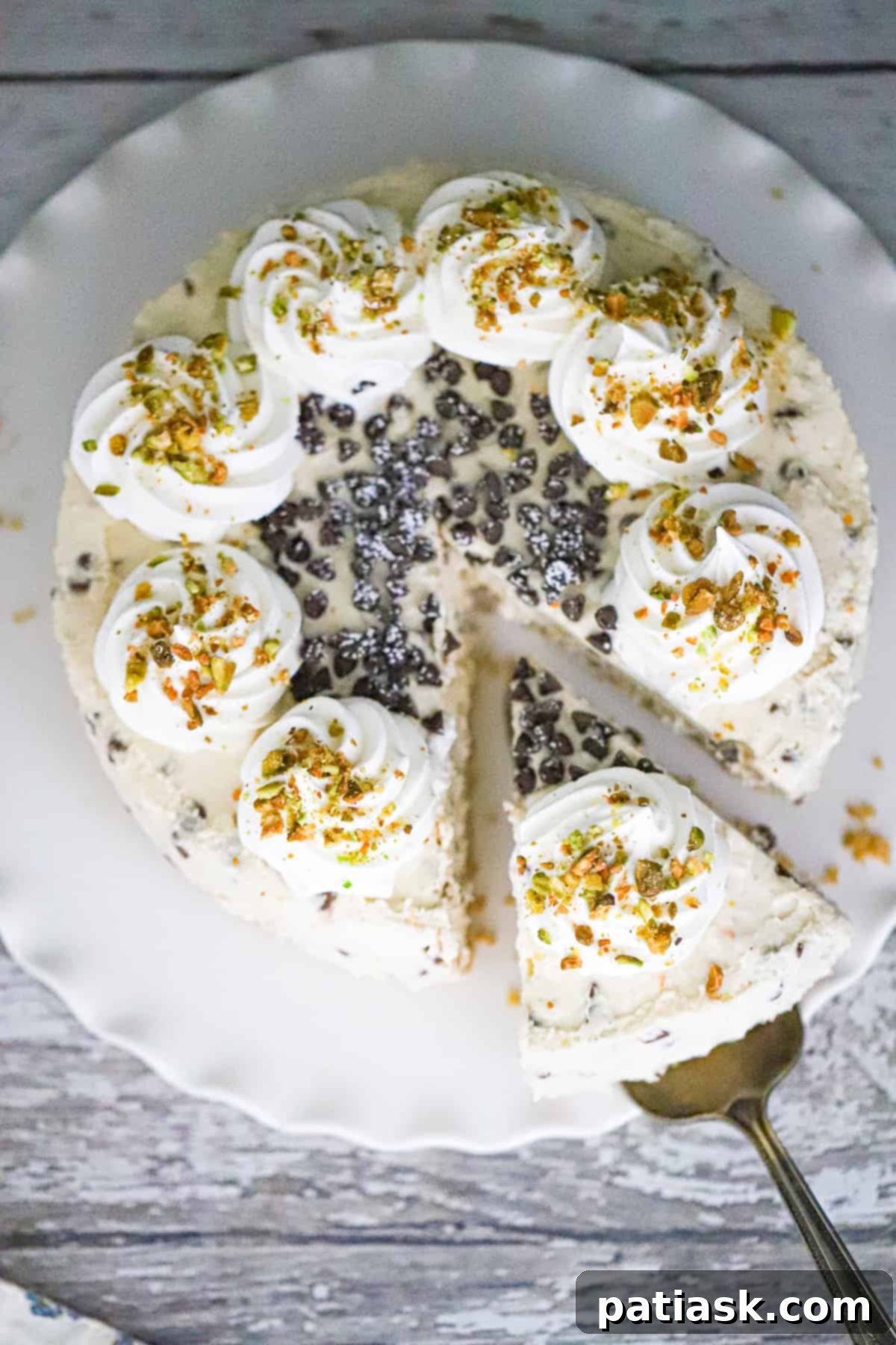 A close-up shot of a sliced No-Bake Cannoli Cheesecake, showing the creamy texture and chocolate chips.
