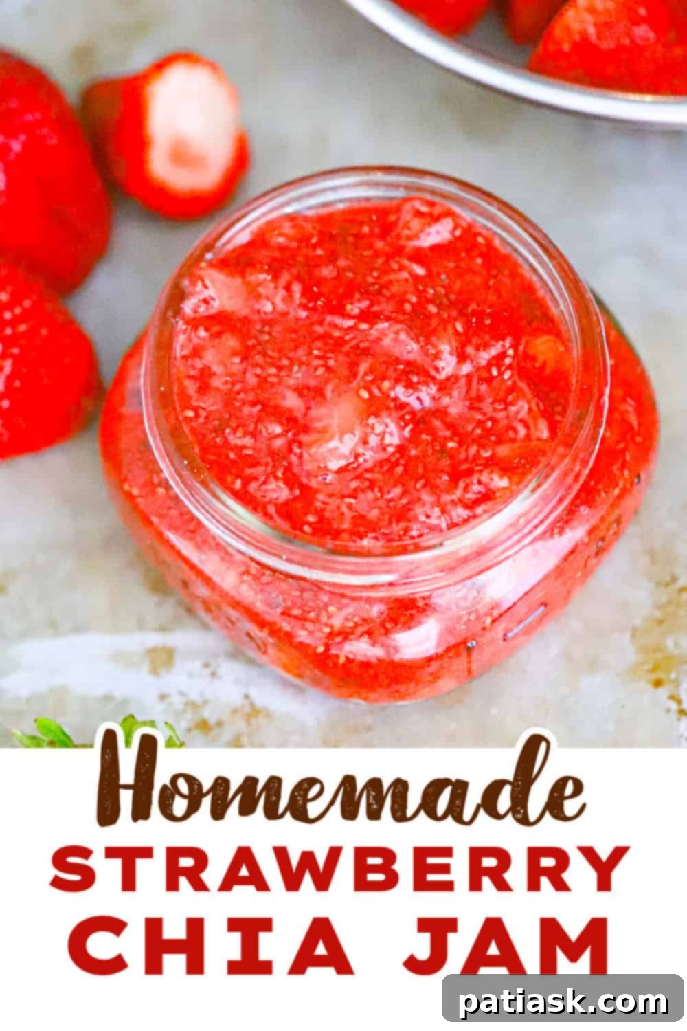 Wholesome Strawberry Chia Jam 9 Bright red strawberry chia jam in a clear jar, decorated with a leaf and twine