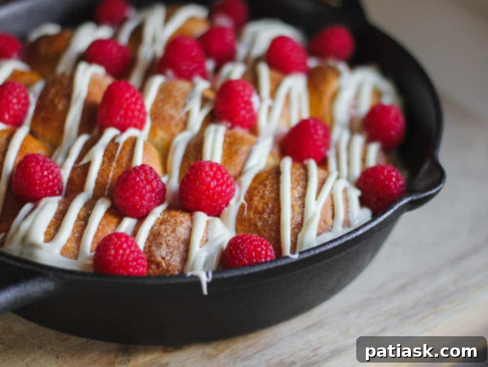 Heavenly Raspberry White Chocolate Sharing Rolls 15 A full skillet of warm Skillet Raspberry-White Chocolate Pull-Apart Rolls, garnished and ready to be served.