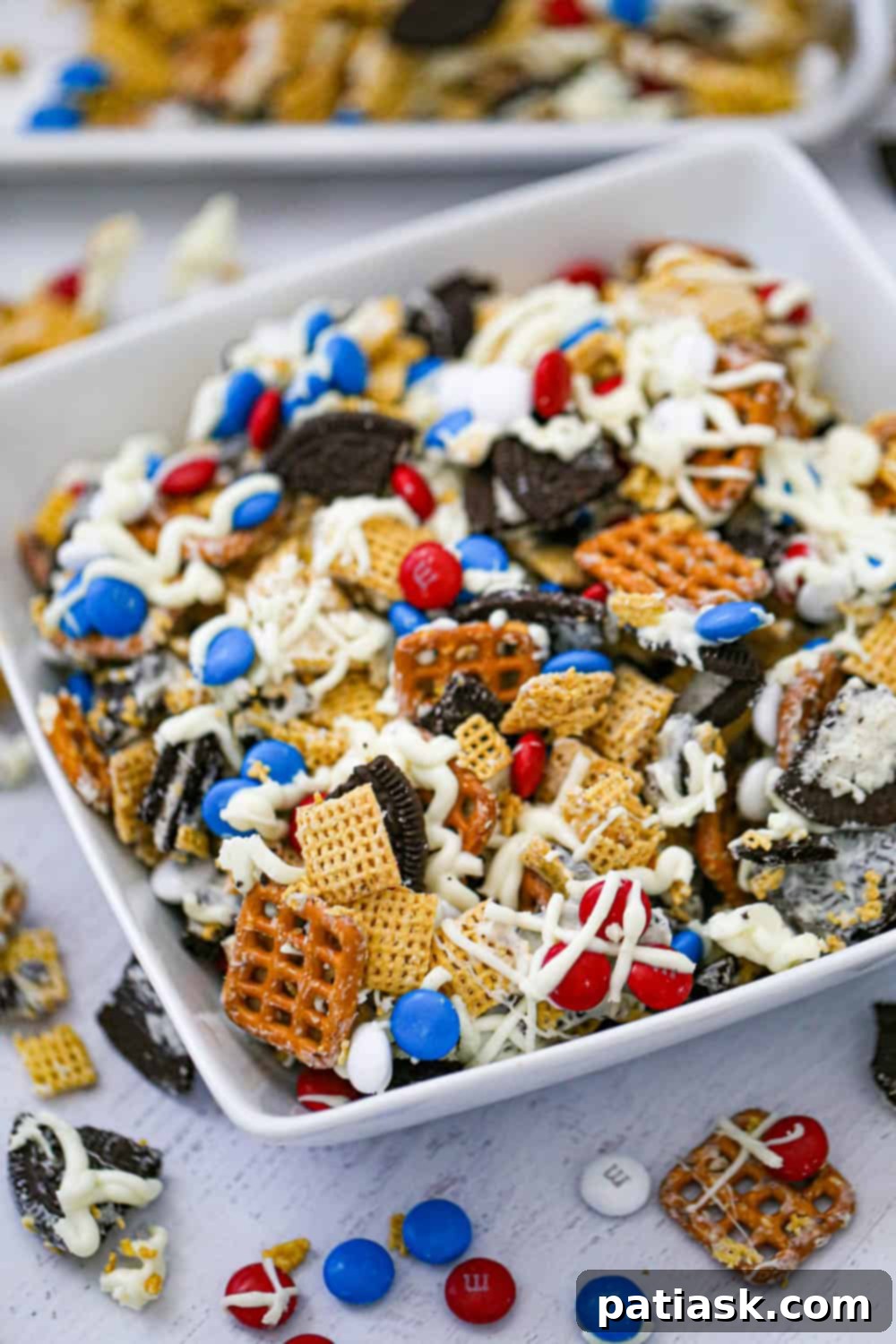 Red White and Blue Chex Crunch 2 Vibrant Patriotic Chex Party Mix, showcasing red, white, and blue M&Ms, pretzels, and white chocolate drizzle