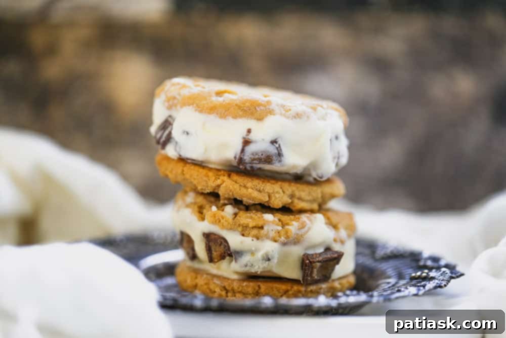Multiple Peanut Butter Cookie Ice Cream Sandwiches stacked on a wooden board