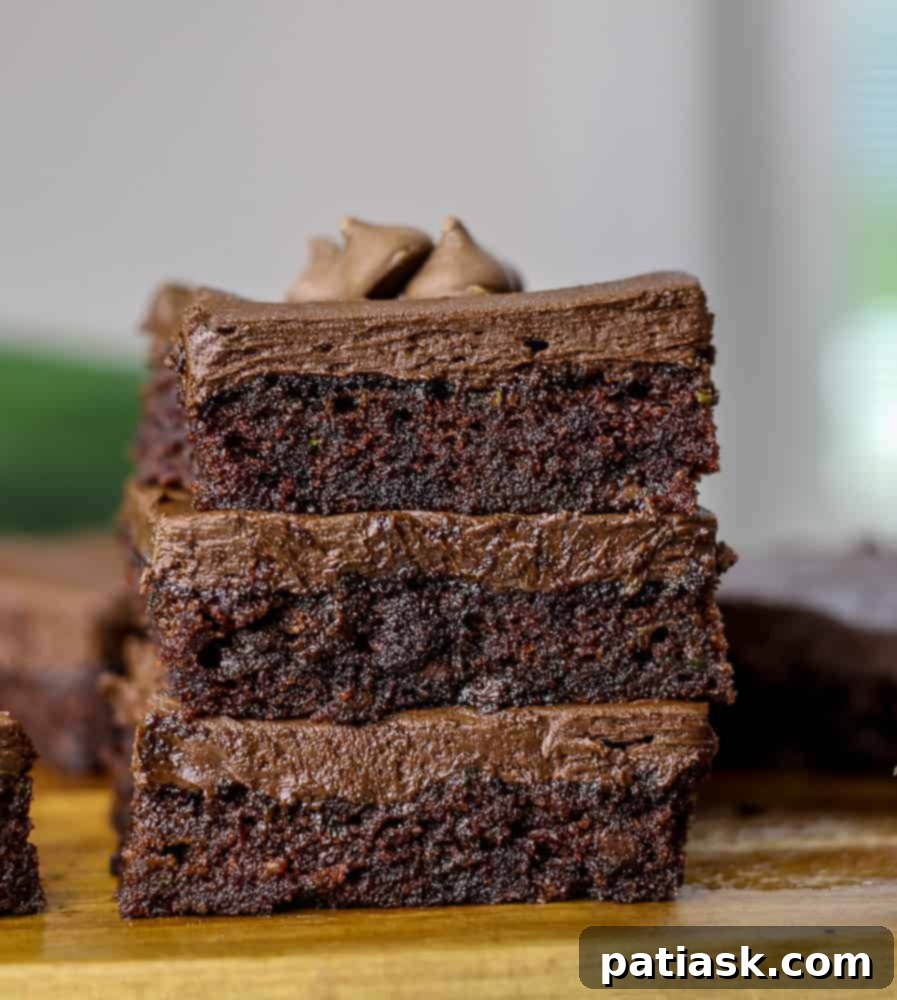 Delicious fudgy cocoa zucchini brownies with chocolate chips and frosting