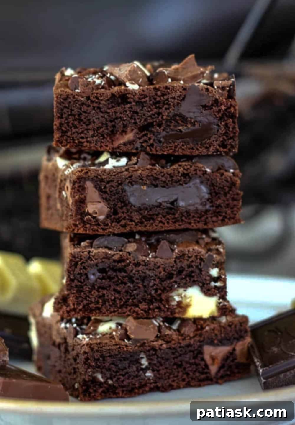 A close-up of a stack of Death By Chocolate Bars, sprinkled with powdered sugar, on a white plate