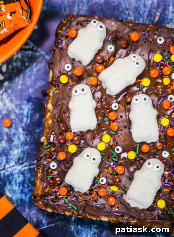 Spooktacular Reeses Monster Cookie Bars 2 Flourless Halloween Reese's Monster Cookie Bars featuring Reese's Ghosts, chocolate, and peanut butter, perfect for a gluten-free Halloween dessert.