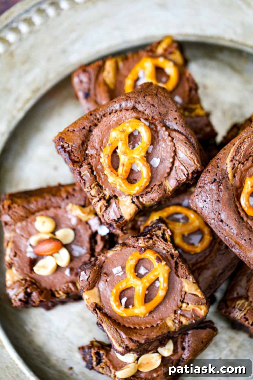 Decadent Nutella and Peanut Butter Cup Brownies 7 A cutting board with several squares of Nutella Peanut Butter Cup Brownies