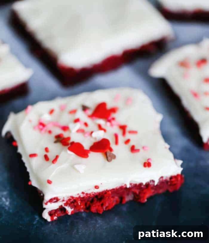 Rich and fudgy red velvet cookie bars with creamy cream cheese frosting, perfect for homemade dessert cravings