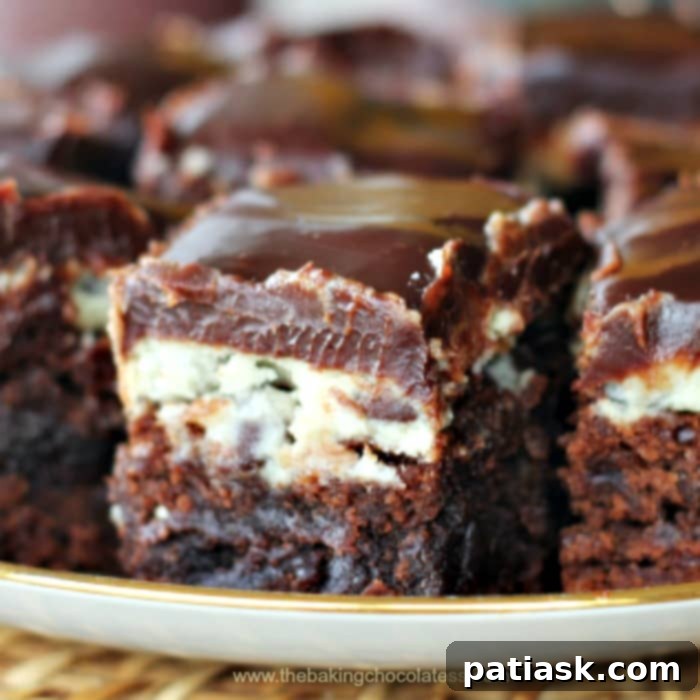 Decadent Cookie Dough Brownie Bars 2 Decadent Cookie Dough Brownies on a white plate, showcasing three delicious layers.