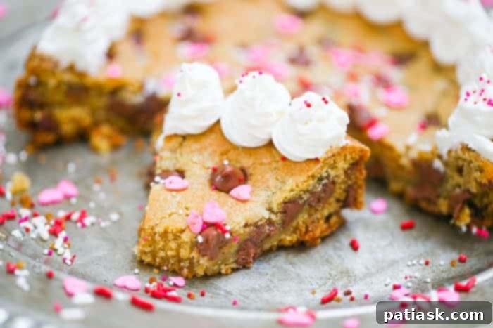 Irresistible Chocolate Chip Celebration Cookie Cake 7 Chocolate chip cookie cake topped with frosting and chocolate chips