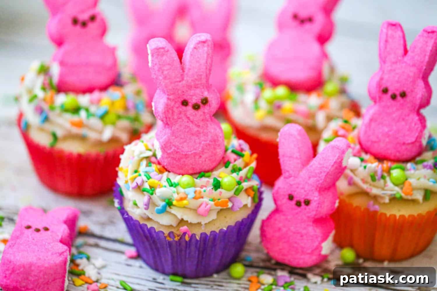 Springtime Peep Bunny Cupcakes 4 Two Easter Bunny Peep cupcakes with green frosting and chocolate eggs, presented on a wooden board