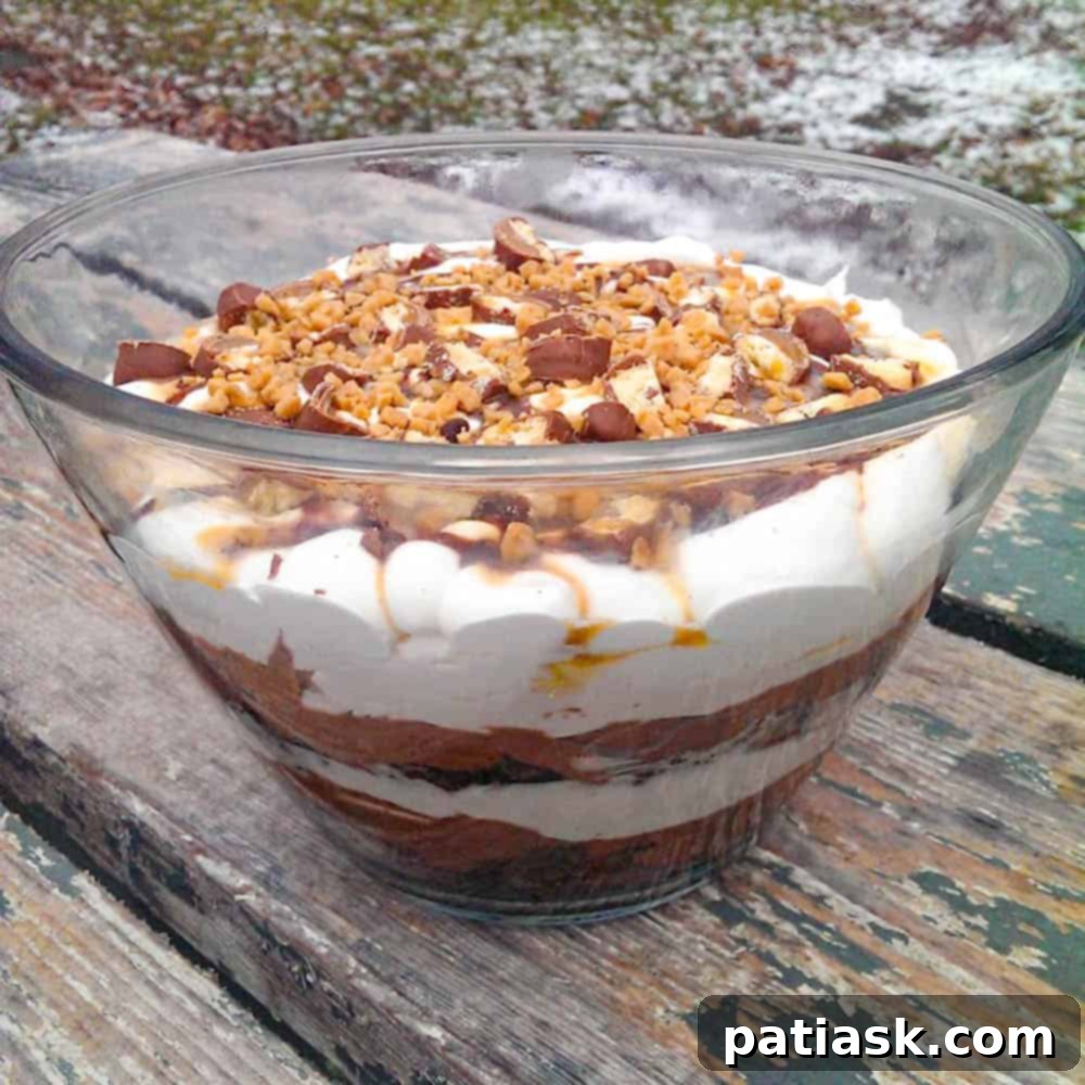 Caramel Brownie Trifle layers with chocolate, whipped cream, and candy toppings