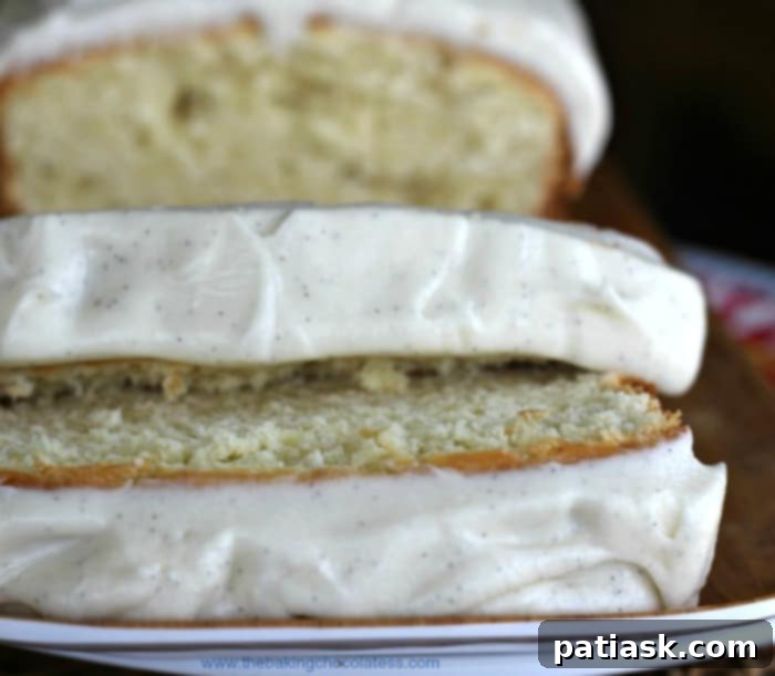 Golden Vanilla Pound Cake with Velvety Vanilla Bean Frosting 6 Close-up of a slice of vanilla loaf cake with vanilla bean frosting, showing its moist crumb.