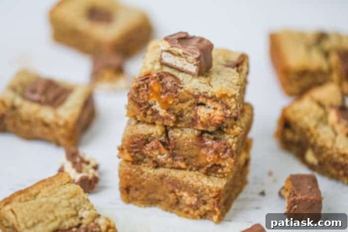 Heavenly Snickers Peanut Butter Blondies 7 An overhead shot of gooey, caramel-filled Snickers Peanut Butter Blondies, highlighting their rich ingredients.