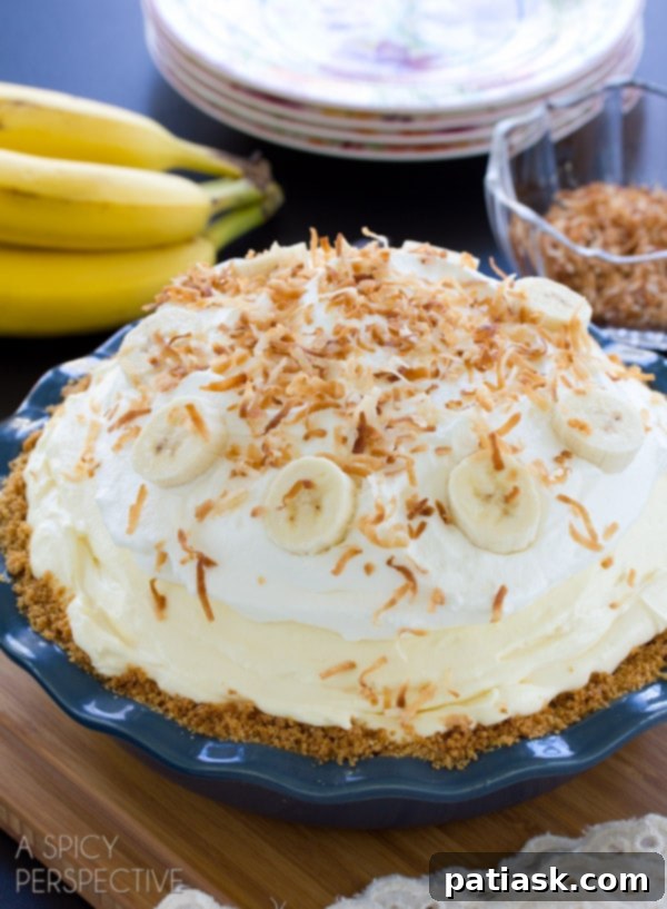 IMG_67262 Delicious Banana Cream Pie from A Spicy Perspective, featuring layers of fresh bananas, creamy vanilla filling, whipped cream, and toasted coconut.