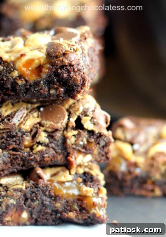 Ultimate Fudgy Snickers Brownies, rich and decadent with chunks of Snickers candy bars.