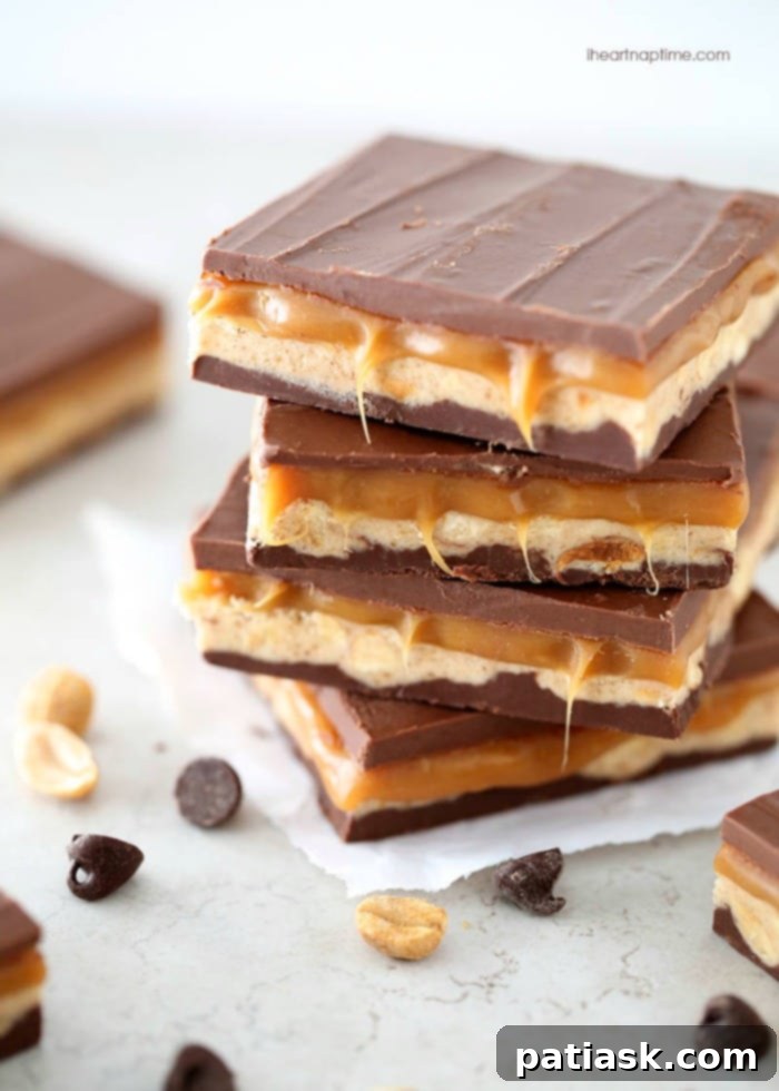Delicious Homemade Snickers bars with layers of chocolate, nougat, caramel, and peanuts.