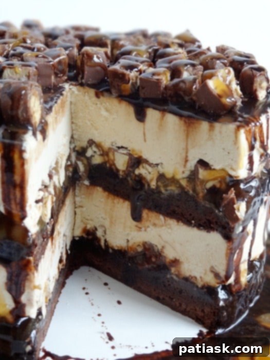 Layers of fudgy brownie, Snickers, peanut butter ice cream, and sauces in a decadent Snickers Peanut Butter Brownie Ice Cream Cake.