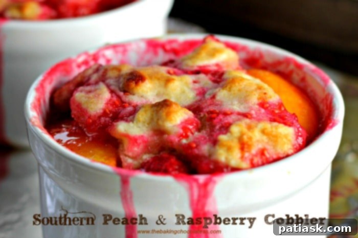 Southern Peach Raspberry Cobbler for Two 2 Southern Peach & Raspberry Cobbler for two, a delectable dessert featuring a golden biscuit top and a vibrant fruit filling.