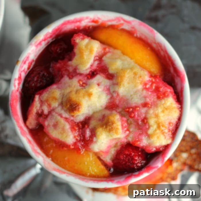 Southern Peach Raspberry Cobbler for Two 5 Two ramekins of Southern Peach & Raspberry Cobbler, garnished with fresh mint, ready to be served.