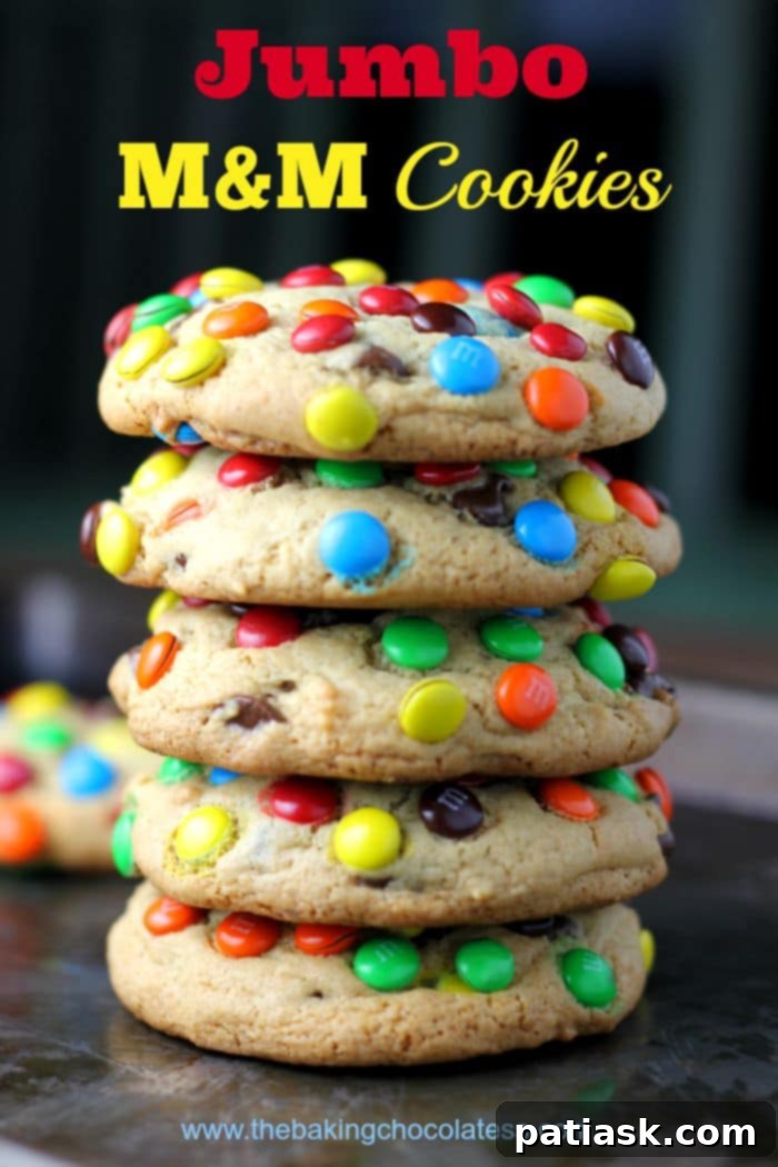 A tall stack of freshly baked jumbo M&M cookies, showcasing their soft texture and colorful candy shells.