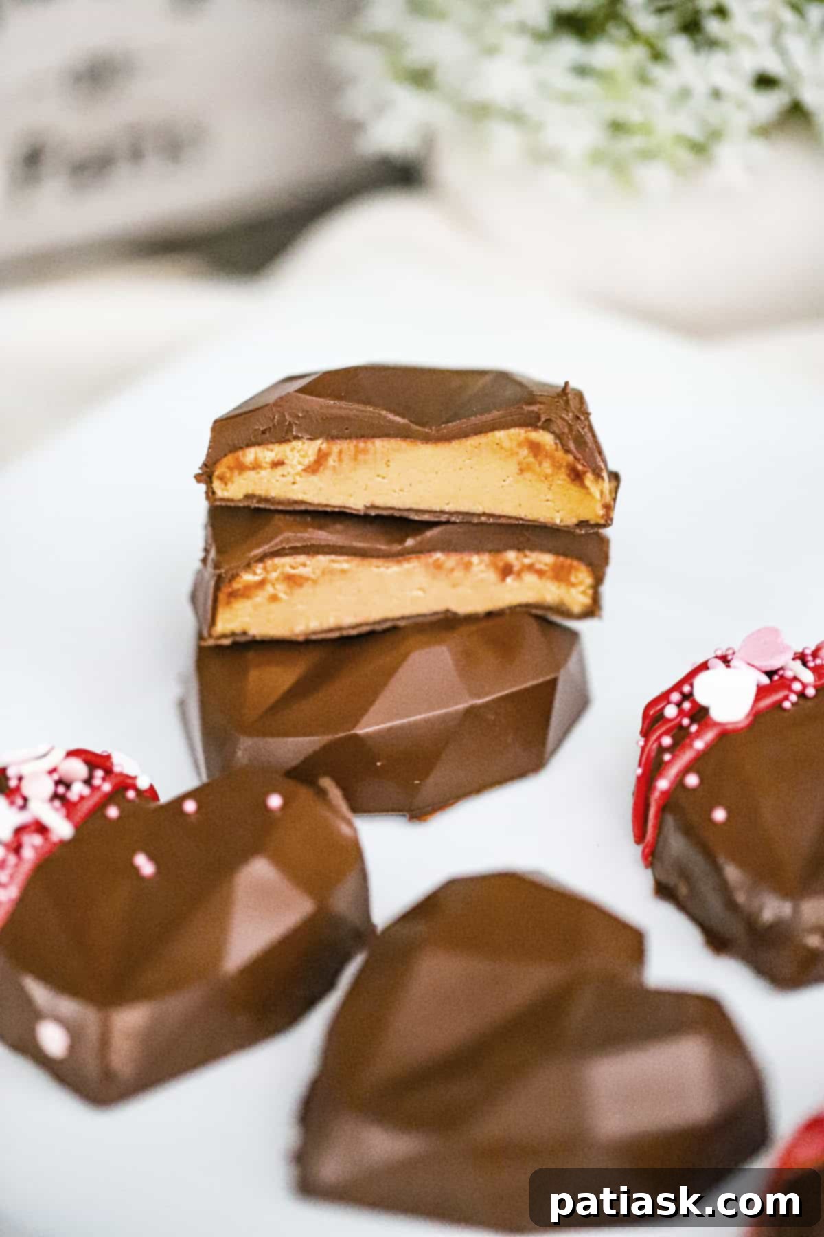 Homemade Reese's peanut butter hearts in geometric shapes with a glossy chocolate finish