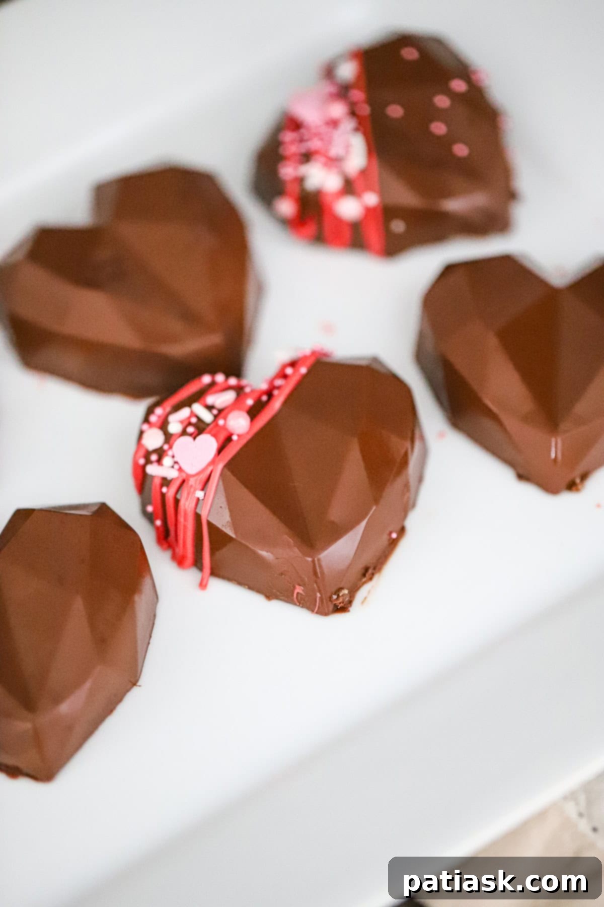 Close-up of homemade chocolate peanut butter hearts showcasing the glossy chocolate finish and creamy filling